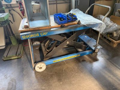 an image of a scissor sitting on a table in a garage