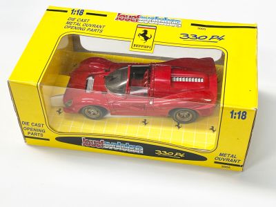 une petite voiture rouge dans une boîte jaune posée sur une surface blanche