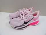 pink and black nike running shoes on a white surface