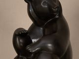 sculpture représentant un ours noir assis sur le dos sur une table