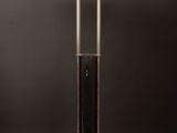 a black and white lamp on a wooden table with a black background
