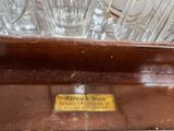 a wooden shelf with glasses on it and a sign on the shelf