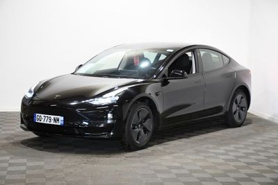 une Tesla noire garée dans une pièce au sol en damier