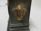 a metal clock with a lion head on it