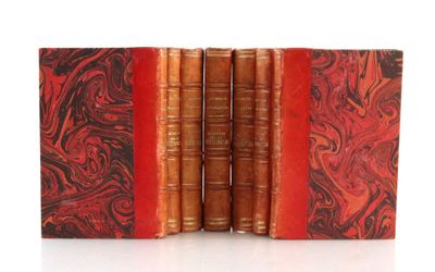 trois vieux livres à la couverture rouge sont empilés les uns sur les autres