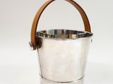 a silver bucket with leather handles on a white background