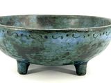 a blue bowl with writing on it sitting on a stand