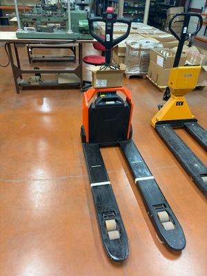 two forklifts that are sitting on the floor in a warehouse