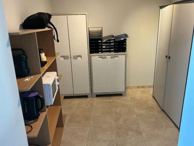 an image of a kitchen with a refrigerator, microwave, and cabinets