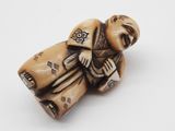 an antique carved ivory figurine of a man with a hat and robe