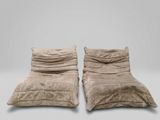 une paire de fauteuils de salon en velours beige, ornés de coussins