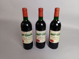 trois bouteilles de vin rouge posées côte à côte sur une table