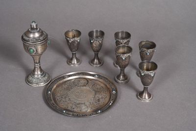 a silver tray with silver cups and a silver tray with silver cups on it