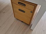 un bureau blanc muni d'un tiroir, posé sur un parquet en bois massif