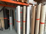 several rolls of paper are stacked on a shelf in a warehouse