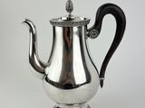 an antique silver tea pot with a black handle on a white background