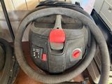 a vacuum that is sitting on the floor with a hose