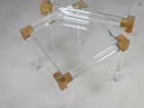 clear acrylic coffee table with wooden legs and a glass top