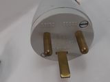 a white and gold plug on a white surface