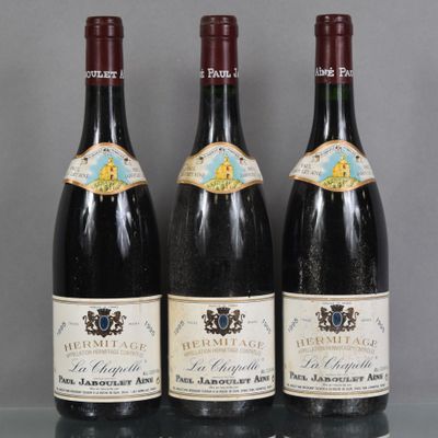 trois bouteilles de vin rouge sont alignées sur une table