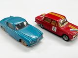 deux voitures jouets assises l'une à côté de l'autre sur une surface blanche