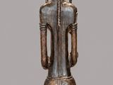 an image of a wooden statue of a man with a bird on his head