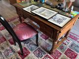 a desk with a chair and a table with pictures on it
