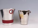 two silver cups with red bands are sitting on a white surface