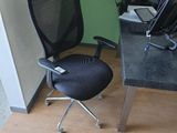 un bureau d'ordinateur avec une chaise et un ordinateur portable posé dessus