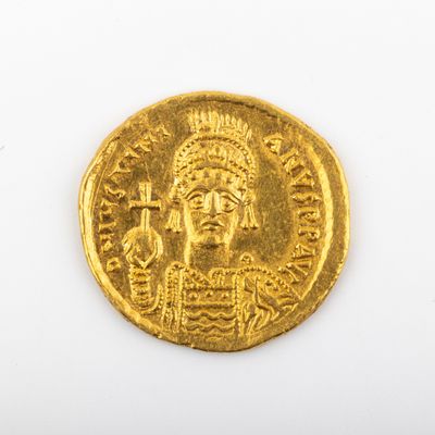 une image représentant une pièce d'or sur laquelle figure un homme coiffé d'une coiffe