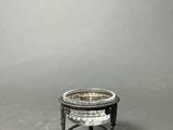 a small silver plate on a stand on a gray surface