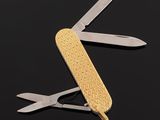 an open swiss army knife on a black surface with a pair of scissors