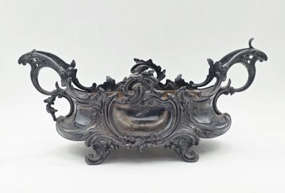 un vase en argent orné d'un dragon sur un fond blanc