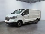La camionnette blanche est garée dans une grande pièce aux murs blancs.