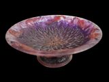 a glass bowl with a purple flower inside of it