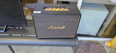 a speaker sitting on top of a table next to a television