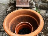 a large clay pot sitting on the ground next to a car