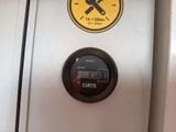 a close up of a clock on the side of a refrigerator
