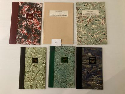 plusieurs livres sont alignés sur une surface blanche