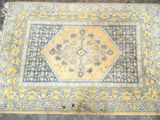 an old rug with a yellow and blue design on it
