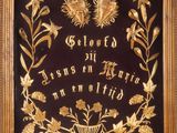 a black and gold plaque with flowers and leaves on it