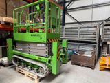 une paire de ciseaux verts posée dans un entrepôt, au milieu de palettes