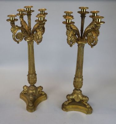 une paire de candélabres anciens en laiton sur socles, sur fond blanc