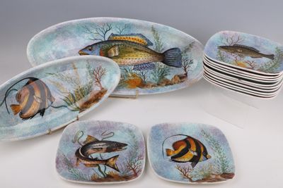 de nombreuses assiettes ornées de poissons, posées sur une table