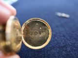 a close up of a person holding a gold pocket watch