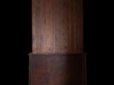 a tall wooden cabinet with a door on top of it