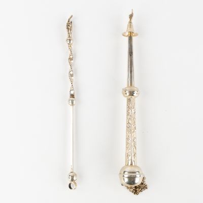 two silver spoons and a silver spoon on a white surface