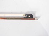 a violin bow and a bow rest on a white surface