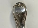 a silver spoon with a design on it on a table