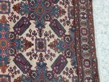 an old rug is laying on the floor next to a white wall